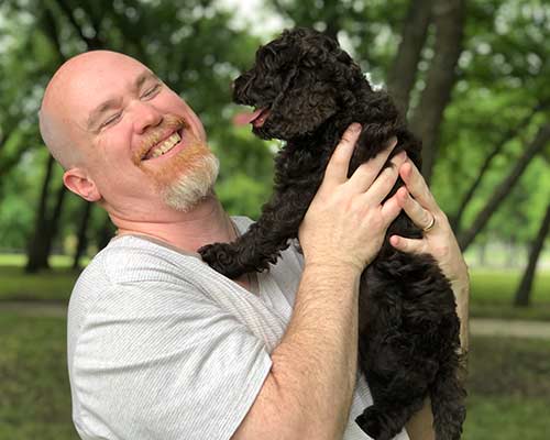 happy owner with black labradoodle